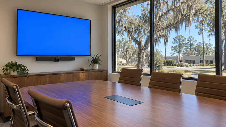 Commercial conference room with a wall display, soundbar with videoconference camera and meeting table
