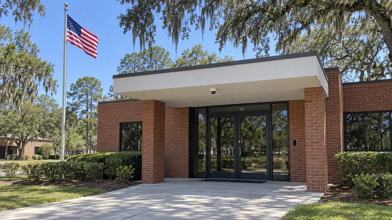 County office entrance with a card reader at the door and a dome camera under the entrance canopy