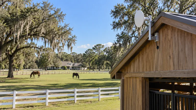 Point-to-point radio on a detached barn aimed across a pasture toward the main house of a residential property